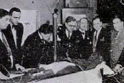 Several men examing a corpse