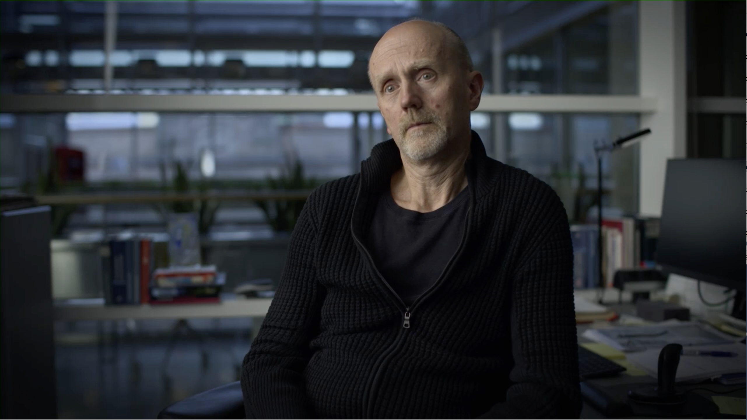 Man in black sweater sitting in an office