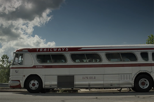 Bus parked outside with clouds