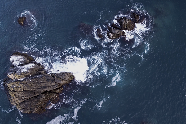 waves crash into rocks
