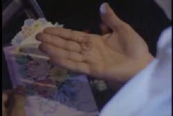 A man holding a birthday card and Cecilia's rings in his hands.