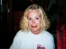 A middle aged caucasian woman with should length blech blonde hair and wearing a white sweater, Colleen Wood.