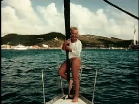 Colleen Wood on the bow of a ship posing next to the mast.