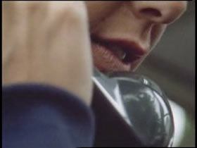 A man is holding an old landline phone to his face.