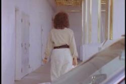 A woman in a white outfit walking from a car into the entrance of a casino.