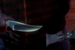 A gloved hand holding a hunting knife.