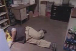 A man laying on the ground of the back office of the grocery store.
