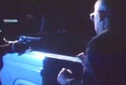 A man holding a revolver up to Rivera outside his car