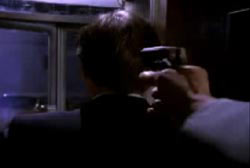 A man holding a small gun to the back of Jay Given's head