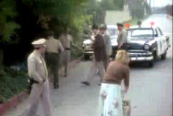 Police investigators crowded around an opening off the side of the road