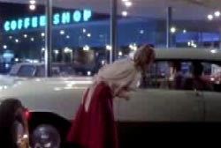 Jean talking to a man from the passenger side window of a car