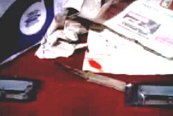 Crumpled up paper on the floor around a bloodied steak knife