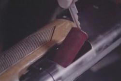 An investigator removing a shotgun shell from a shotgun