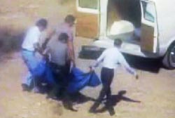 Police officers and paramedics carrying Katherine's body onto an ambulance