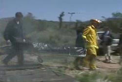 A fire fighter and EMT wheeling one of the Freemans to an ambulance