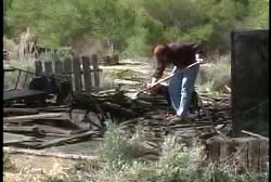 Jay Bible shoveling through the burnt remains of the house