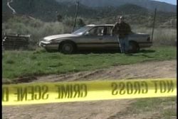 A man walking towards the yellow tape of a crime scene