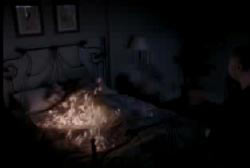 Man standing over the bed thats engulfed in flames