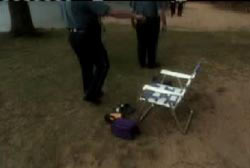 Police investigator's standing around an empty chair and small purple bag