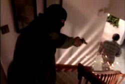 The gunman stands at the top of a staircase, shooting the banister right next to Roger
