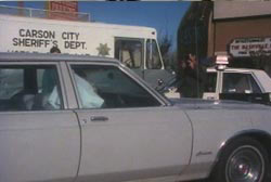 Terri slumped over in the passanger seat of her car as a police investigator photographs the scene