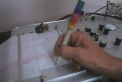 A person using a pen to analyse a polygraph test