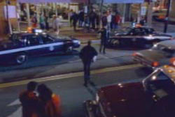 A man standing in the middle of the street outside of a social gathering