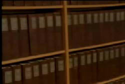 A large bookshelf with many volumes of brown leather bound books