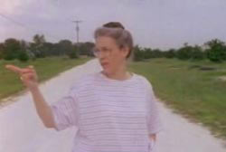 Nancy in glasses pointing off to the side of the road