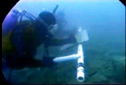 A scubadiver deep in the water of lake michigan scanning its floor 