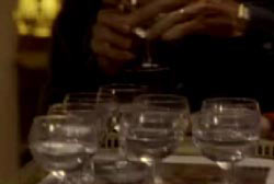 A man in front of wine glasses filled with alcohol 