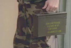 Man in army uniform holding a container