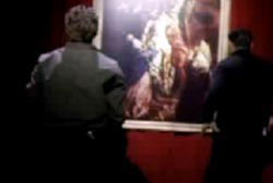 Ben hanging up a large painting in a museum showroom