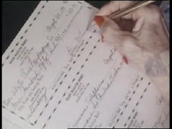 Ellen Berry's hand signing three checks with a pen