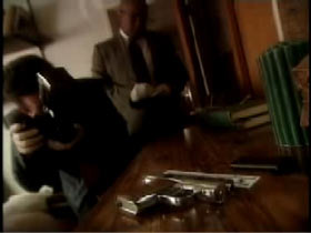 Police Investigator and Photographer taking picture of gun on a table at the crime scene