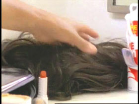 A man grabbing a wig and lipstick