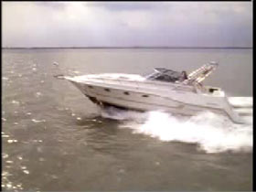 Philip Breen at the helm of a white yacht cruising on the water
