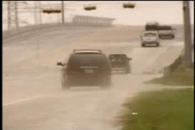 A mini-van kicking up dust as it speeds off onto a highway
