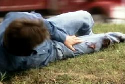 A man in severe pain clutching his injured leg 