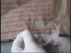 Gloved hands examine a bullet removed from Fischer's wall 
